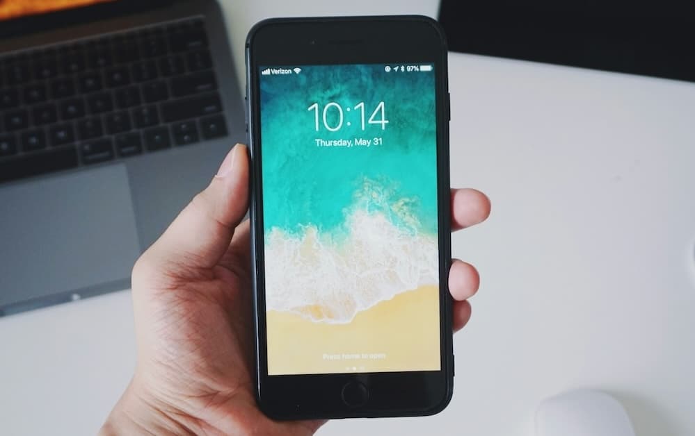 Hand holding smartphone with recycling symbol